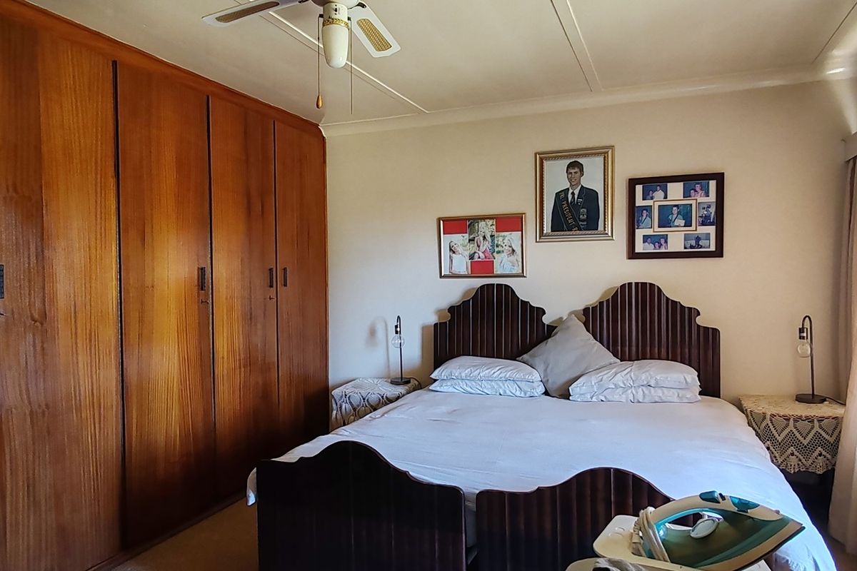 A bedroom featuring extensive built-in wooden cabinetry and a ceiling fan, offering functional storage space.