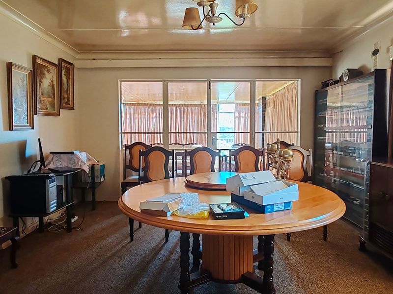 A dated dining room featuring carpet flooring and large sliding glass doors leading to an adjacent patio area.