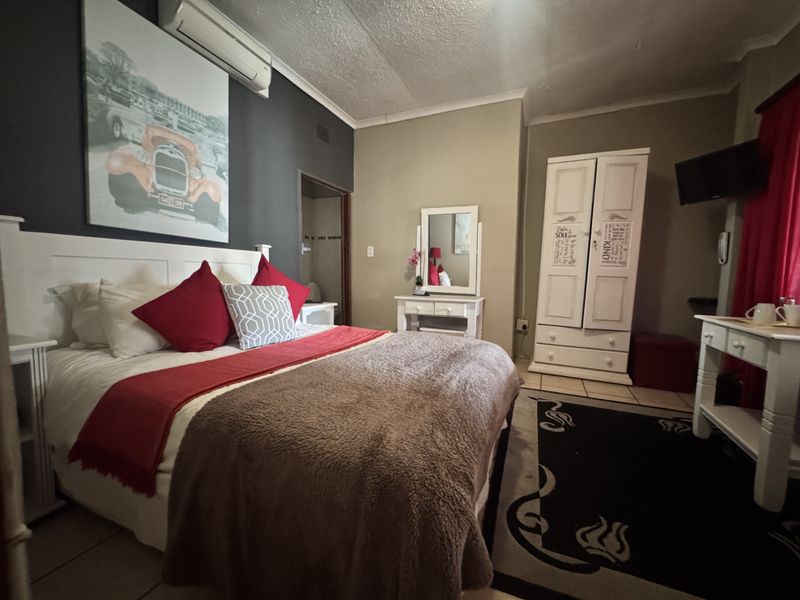 A bedroom featuring tiled flooring and a wall-mounted split-system air conditioning unit.