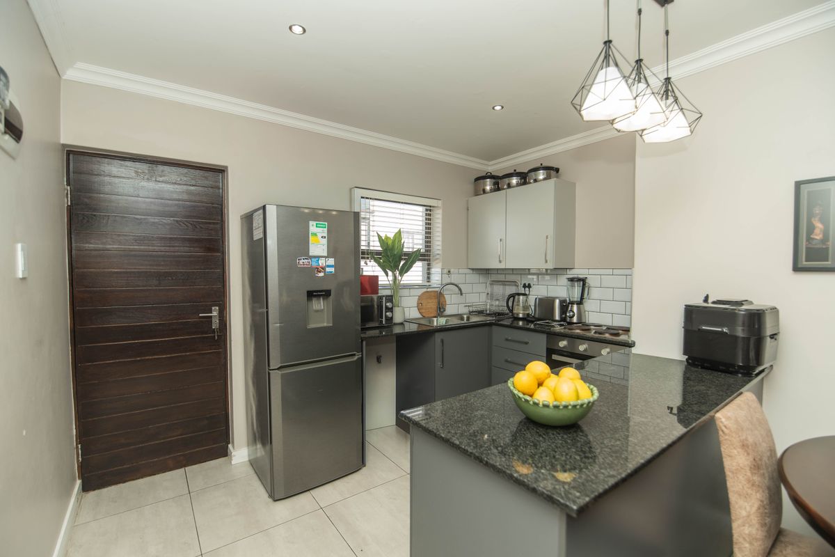 Modern kitchen featuring granite countertops, subway tile backsplash, built-in cabinetry, and recessed lighting, offering a clean and functional cooking space.