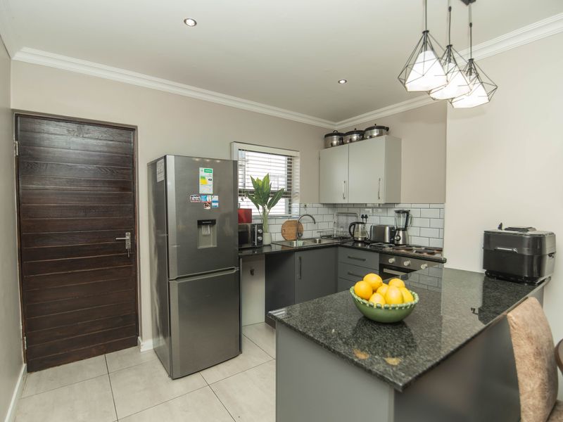 Modern kitchen featuring granite countertops, subway tile backsplash, built-in cabinetry, and recessed lighting, offering a clean and functional cooking space.