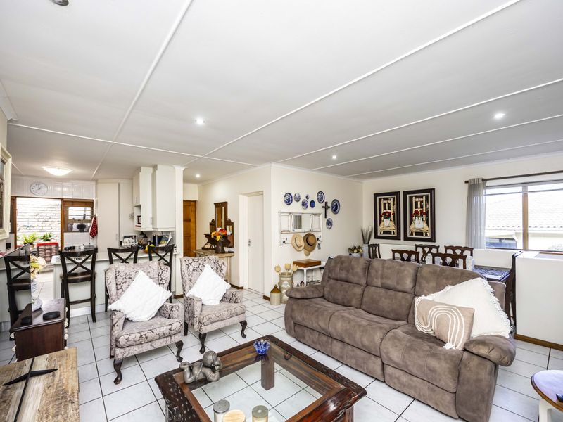 Open plan living and dining area featuring tiled flooring, recessed lighting, and an integrated kitchen space with a breakfast bar.
