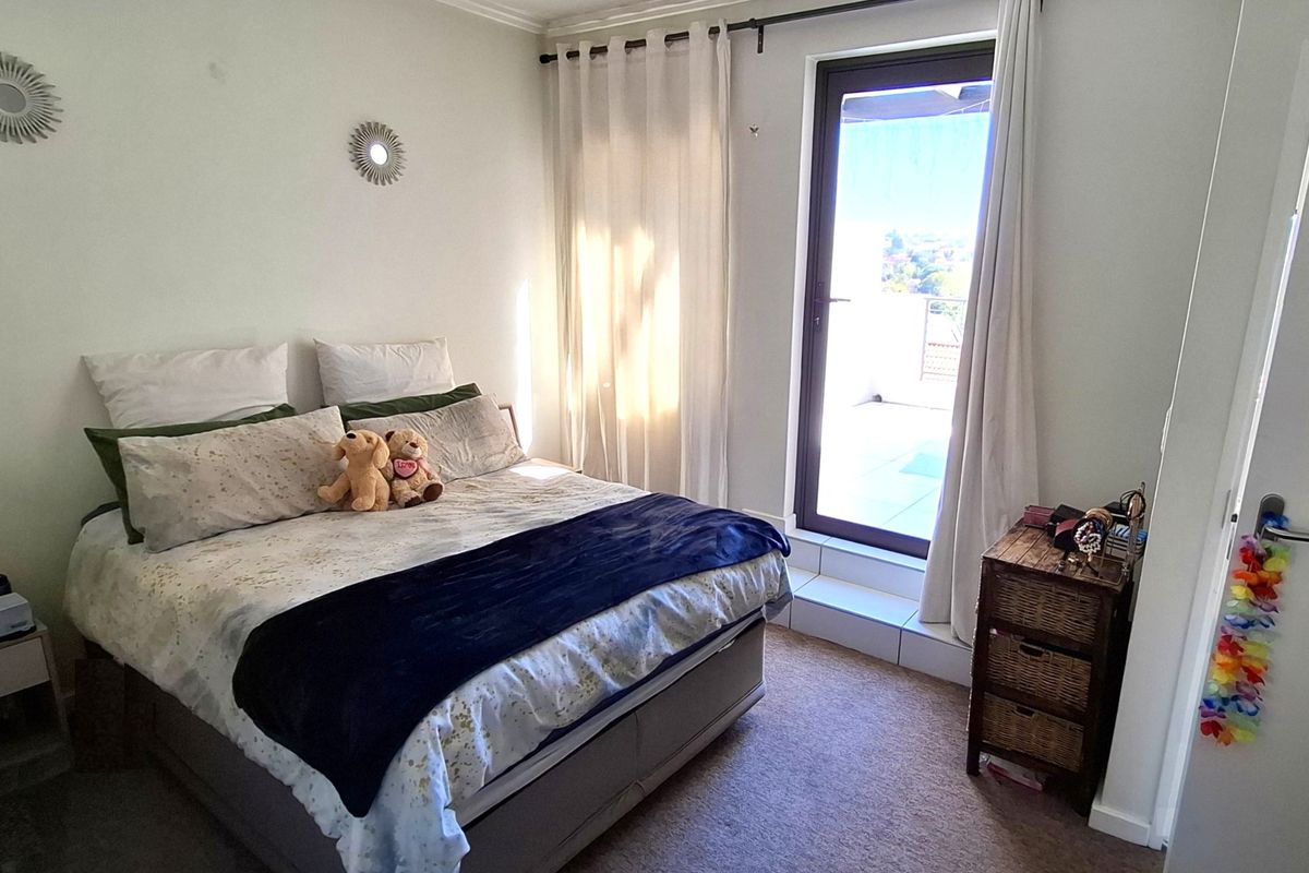 A bedroom featuring carpeted flooring and a glass sliding door providing access to an outdoor area.