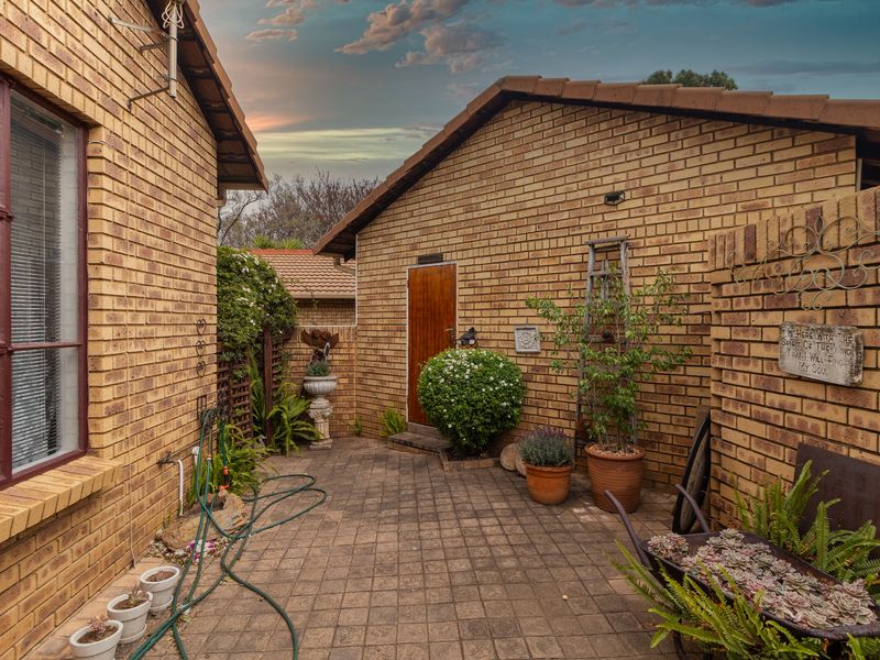 A private rear courtyard featuring face brick walls, paved flooring, and a secure entrance door, providing a low-maintenance outdoor space.