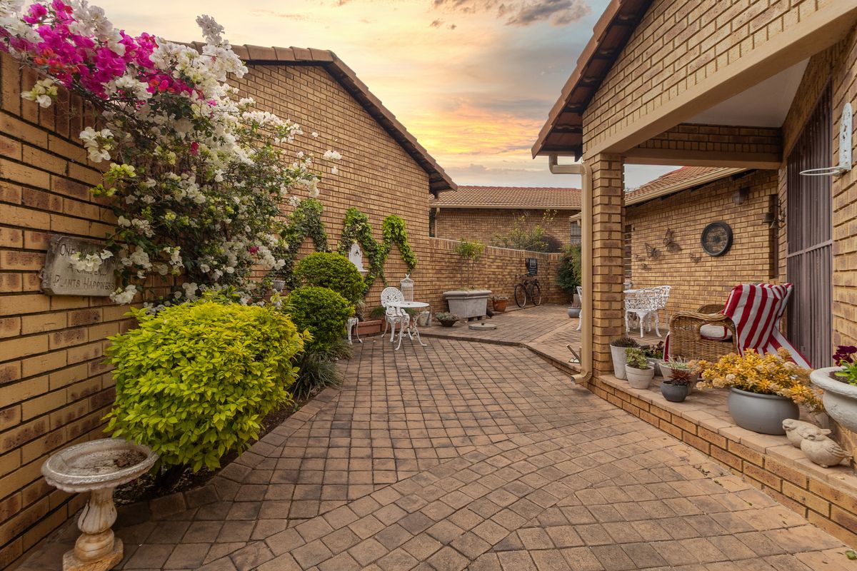 A well-maintained rear courtyard featuring brick paving, face brick walls, and a covered patio area, perfect for outdoor relaxation.