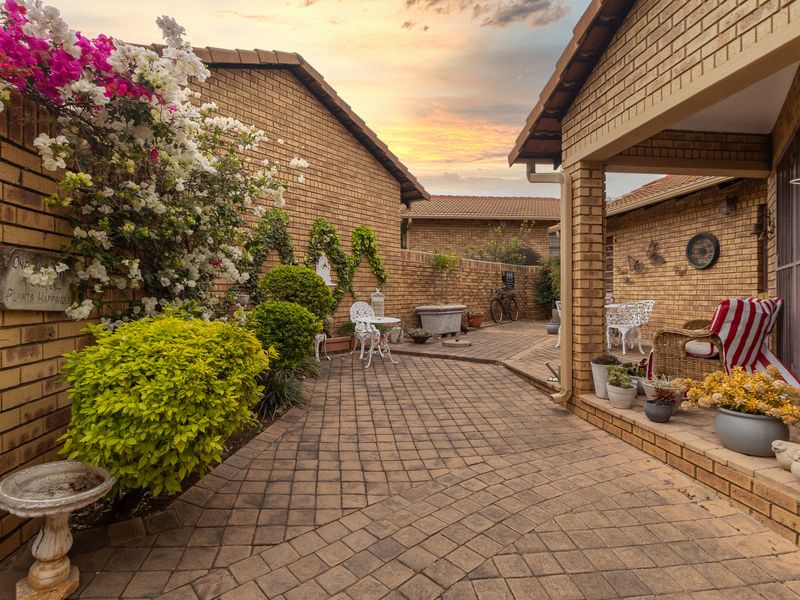 A well-maintained rear courtyard featuring brick paving, face brick walls, and a covered patio area, perfect for outdoor relaxation.
