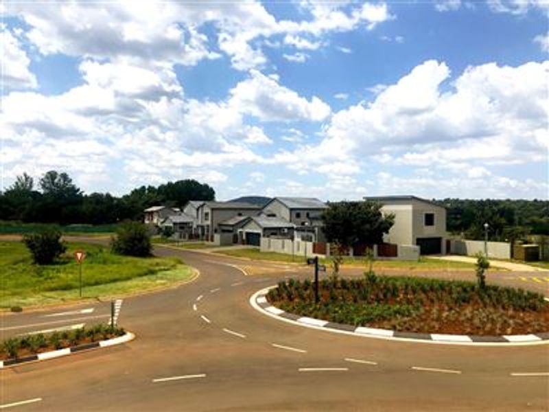 A view of the residential estate street layout, featuring paved roads, a roundabout, and surrounding residential properties.