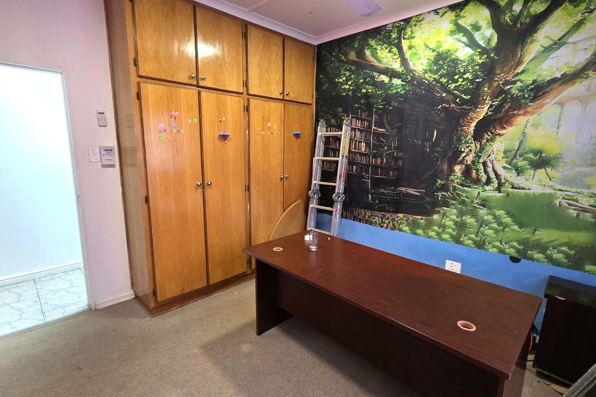 Bedroom featuring extensive built-in wooden cabinetry and carpeted flooring, offering ample storage space and potential for modernization.