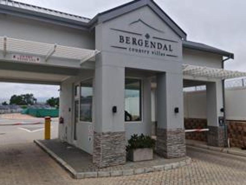 The entrance to Bergendal Country Villas featuring a modern security gatehouse with stone cladding and automated boom gate access.
