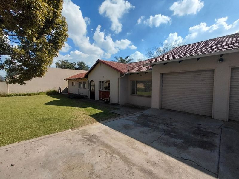 Front view of the house featuring a concrete driveway, attached garage, and a well-maintained lawn area.