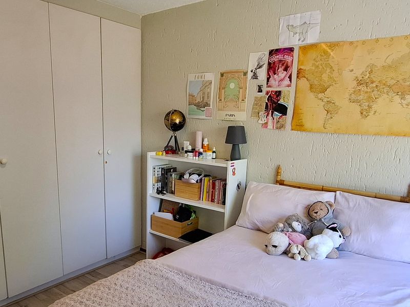 A bedroom featuring built-in wardrobes and textured wall finishes, providing functional storage space.