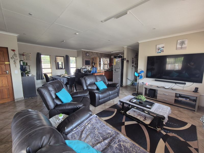 Spacious open-plan living area featuring tiled flooring, recessed lighting, and an integrated kitchen space, providing a functional and connected layout for daily living.