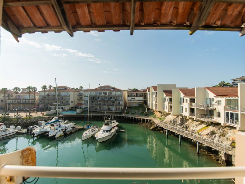 A scenic view overlooking a private marina with docked boats, surrounded by residential apartment complexes.