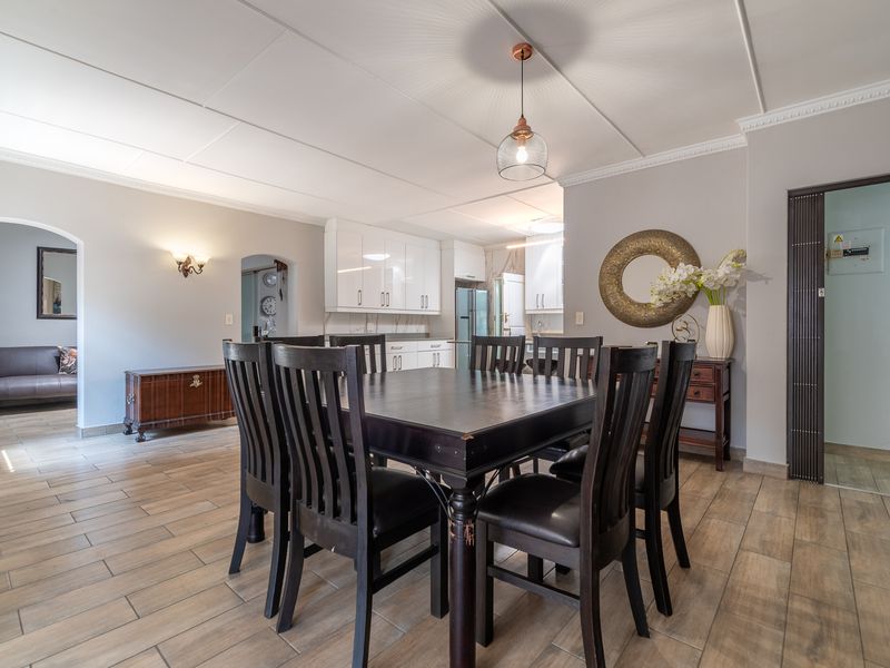 Open-plan dining area featuring tiled flooring, coved ceilings, and a seamless transition into the modern kitchen space.