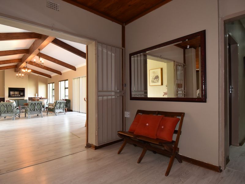 Entrance hall featuring laminate flooring and a timber ceiling, providing a view into the spacious open-plan living area beyond.