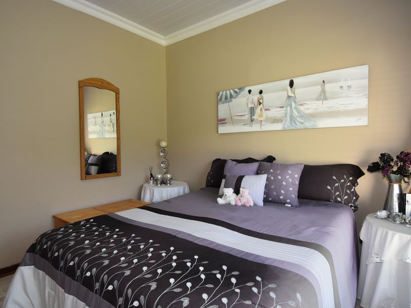 A well-maintained bedroom featuring neutral wall tones, crown molding, and tiled flooring, providing a comfortable and functional sleeping space.