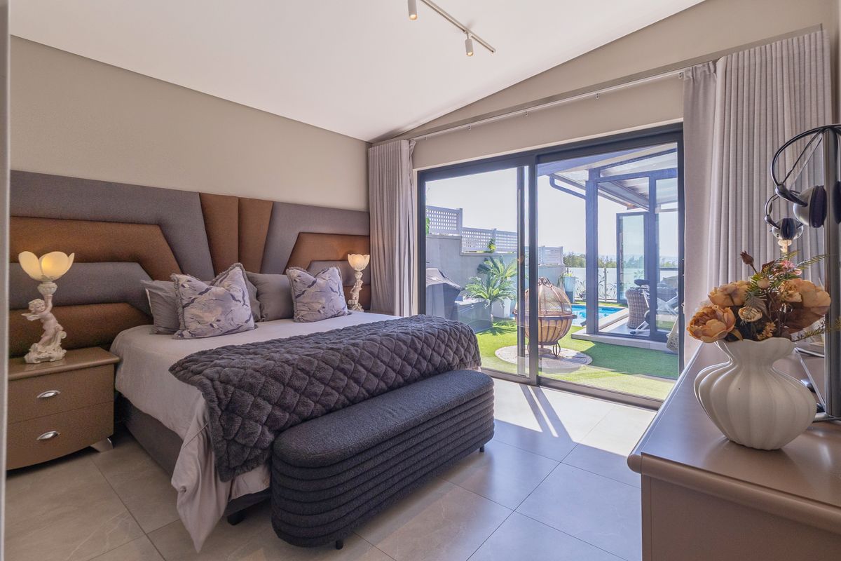 Spacious bedroom featuring large sliding glass doors that provide direct access to a private patio and pool area.
