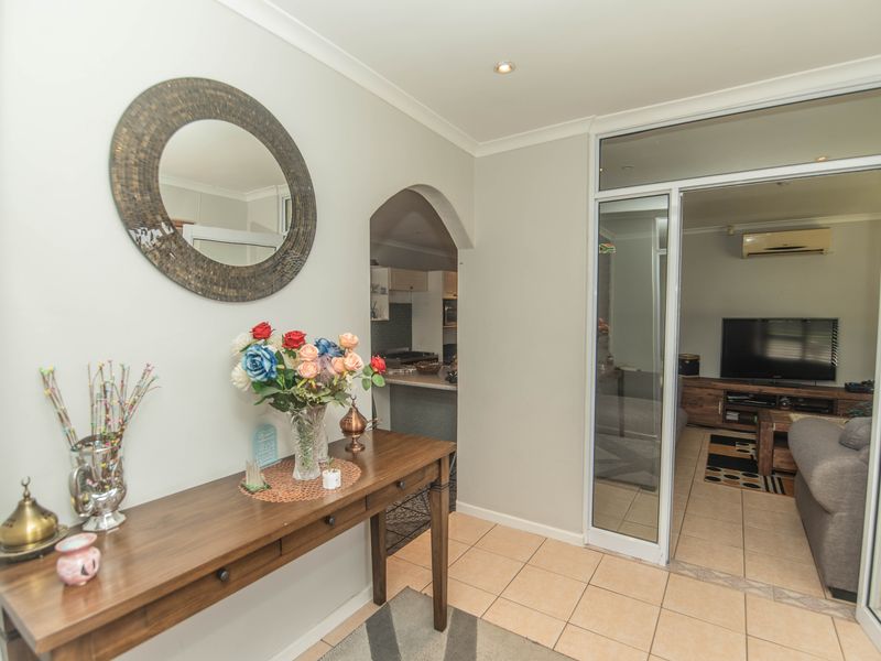 A welcoming entrance hall featuring tiled flooring, recessed lighting, and an arched transition leading into the main living areas.