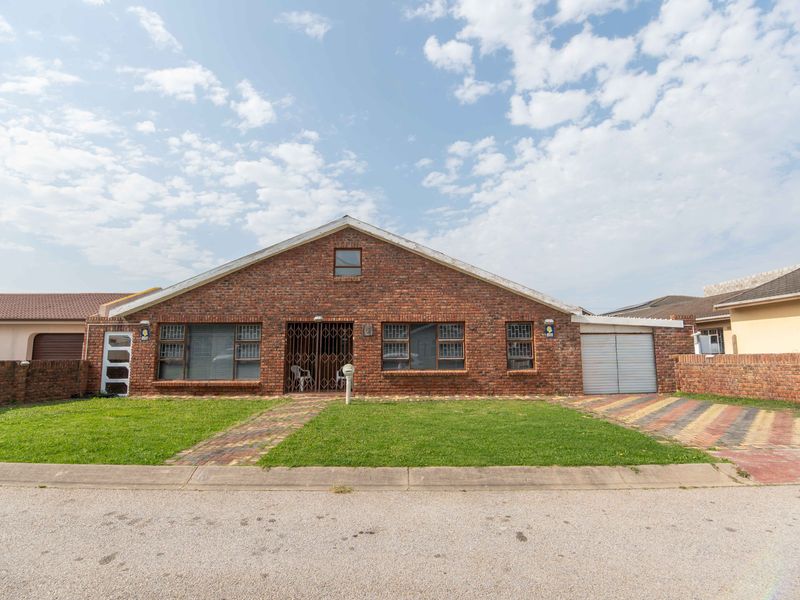 Front view of a face brick house featuring a paved driveway, single garage, and a well-maintained front lawn.