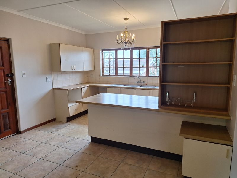 A functional kitchen featuring laminate cabinetry, a breakfast bar, and tiled flooring, offering a blank canvas for modern updates and renovation.