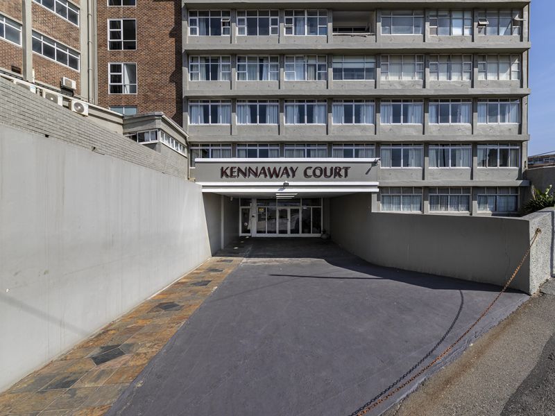 Front entrance view of Kennaway Court apartment building, featuring a paved driveway, concrete retaining walls, and a multi-story residential facade.