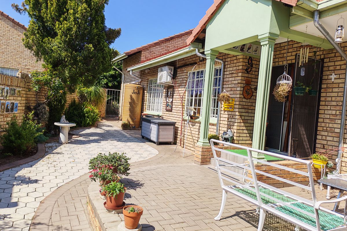 A well-maintained rear patio area featuring brick paving, a covered porch, and a water tank, providing a functional outdoor living space.