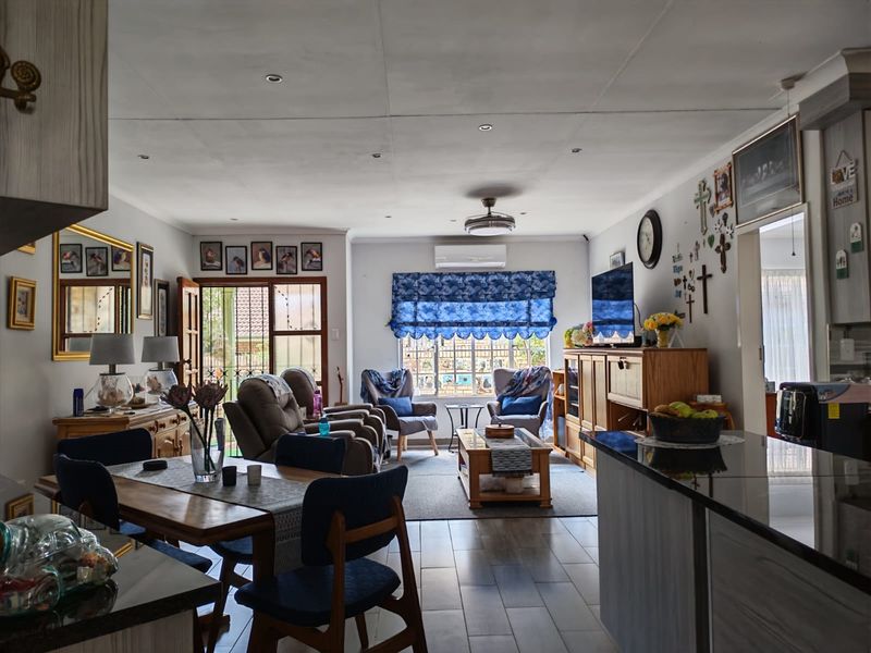 Spacious open-plan living and dining area featuring tiled flooring, recessed lighting, a ceiling fan, and a split-system air conditioner for climate control.