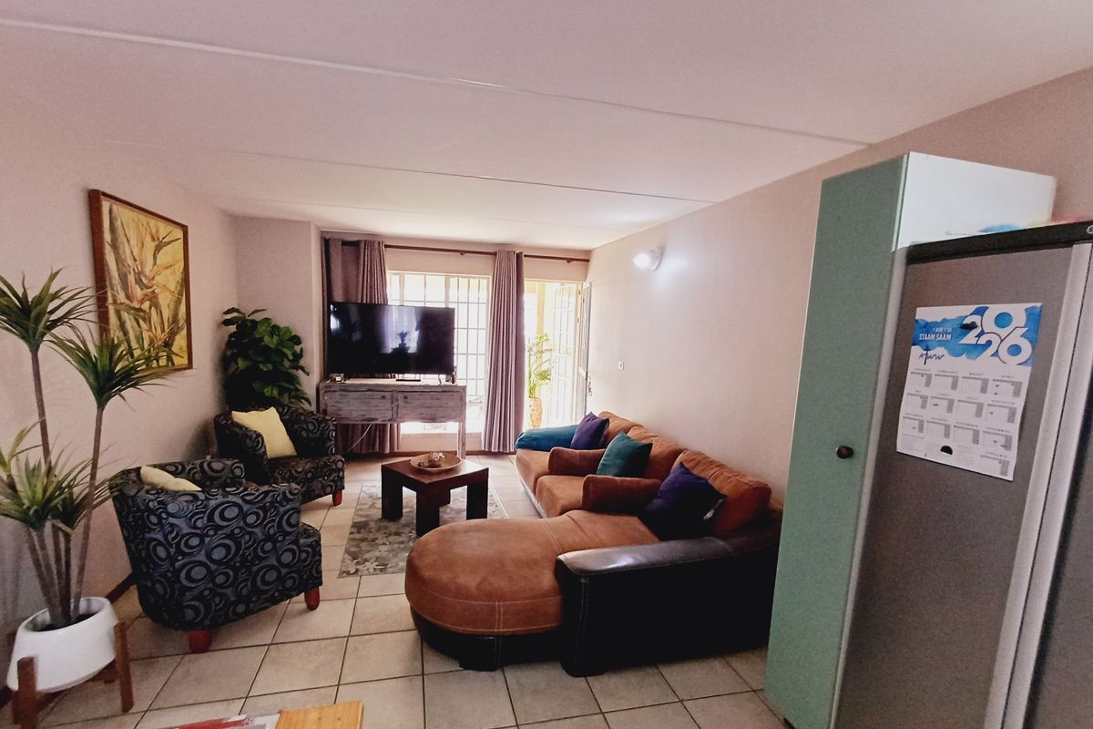 A living room area featuring tiled flooring and a sliding glass door leading to an outdoor space.