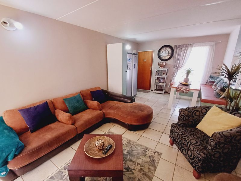 An open-plan living and dining area featuring tiled flooring and neutral wall finishes, providing a functional space for relaxation and meals.