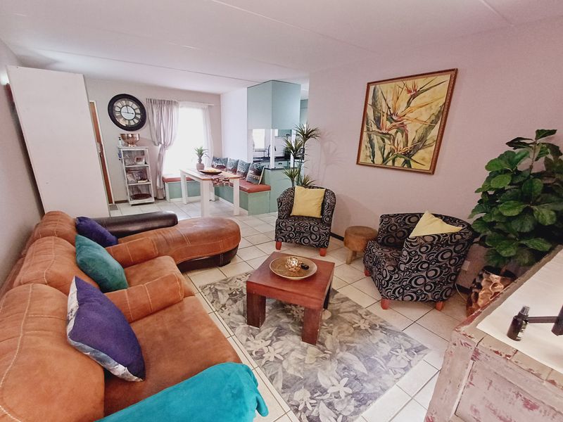 Open plan living and dining area featuring tiled flooring and built-in bench seating, creating a functional and connected living space.