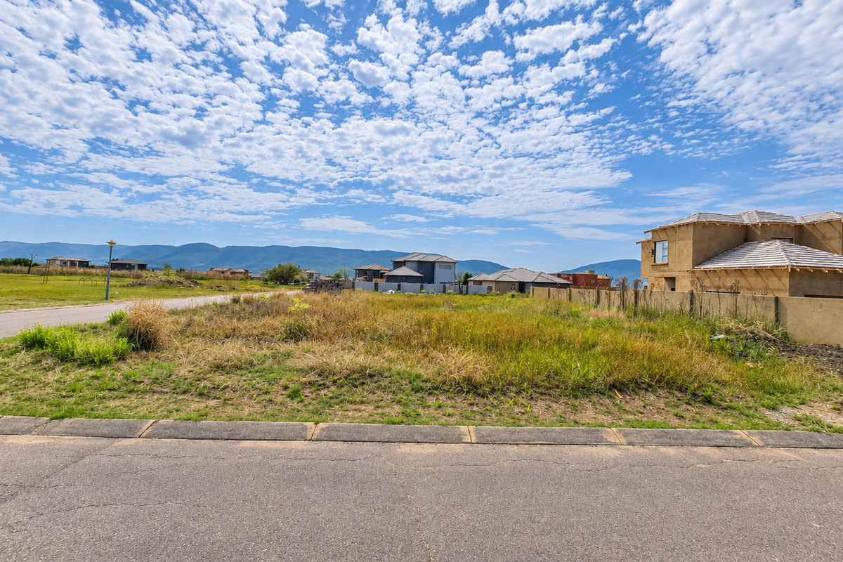 A vacant residential plot situated in a developed estate, featuring mountain views and proximity to existing residential properties.