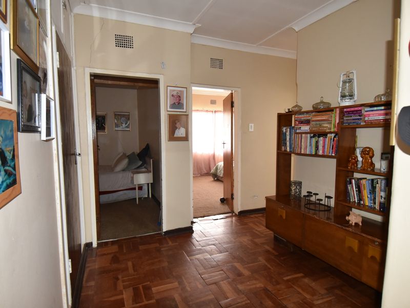 A hallway featuring traditional parquet flooring and coved cornicing, providing access to adjacent bedrooms.
