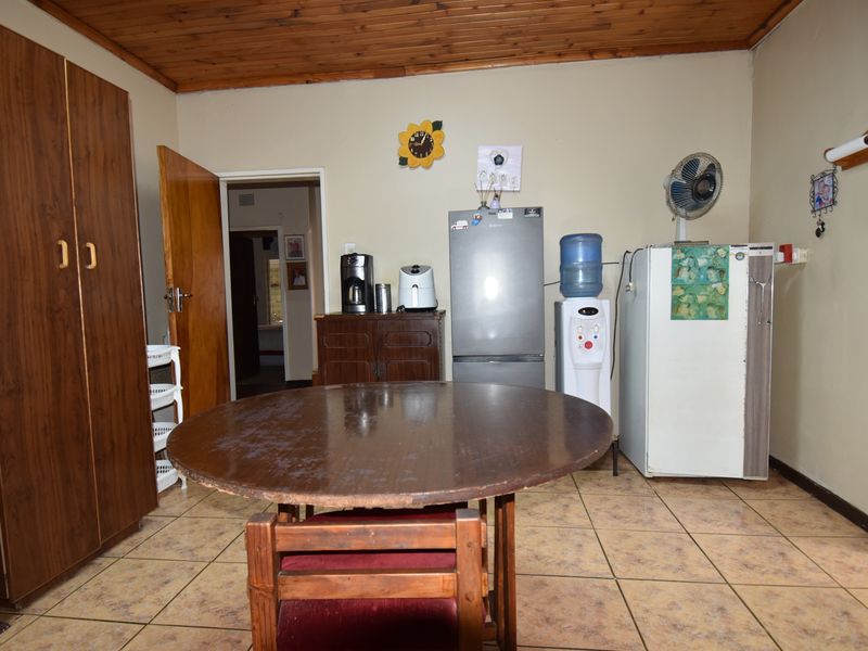 A functional kitchen area featuring tiled flooring and a timber ceiling, offering a dated aesthetic with potential for modernization.