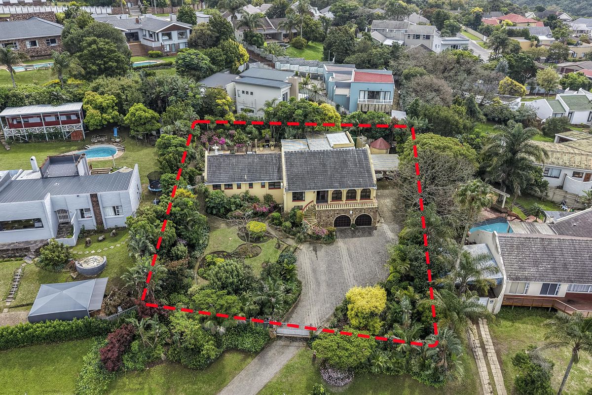 Aerial view of a residential property featuring a tiled roof house, established garden, and paved driveway within a suburban estate setting.