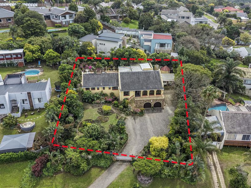 Aerial view of a residential property featuring a tiled roof house, established garden, and paved driveway within a suburban estate setting.