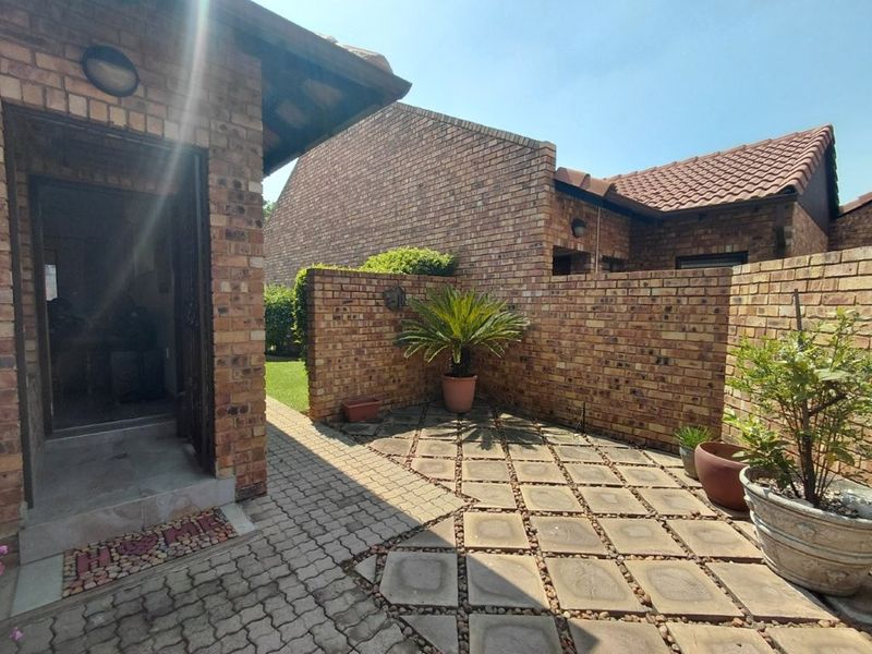 A private rear courtyard featuring face brick walls, paved flooring, and a covered entrance area, providing a low-maintenance outdoor space.