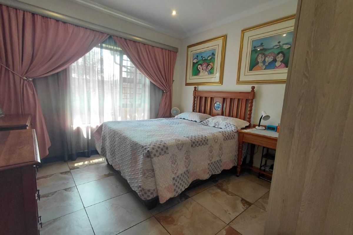 A bedroom featuring tiled flooring, recessed downlighting, and a sliding glass door providing access to the exterior.