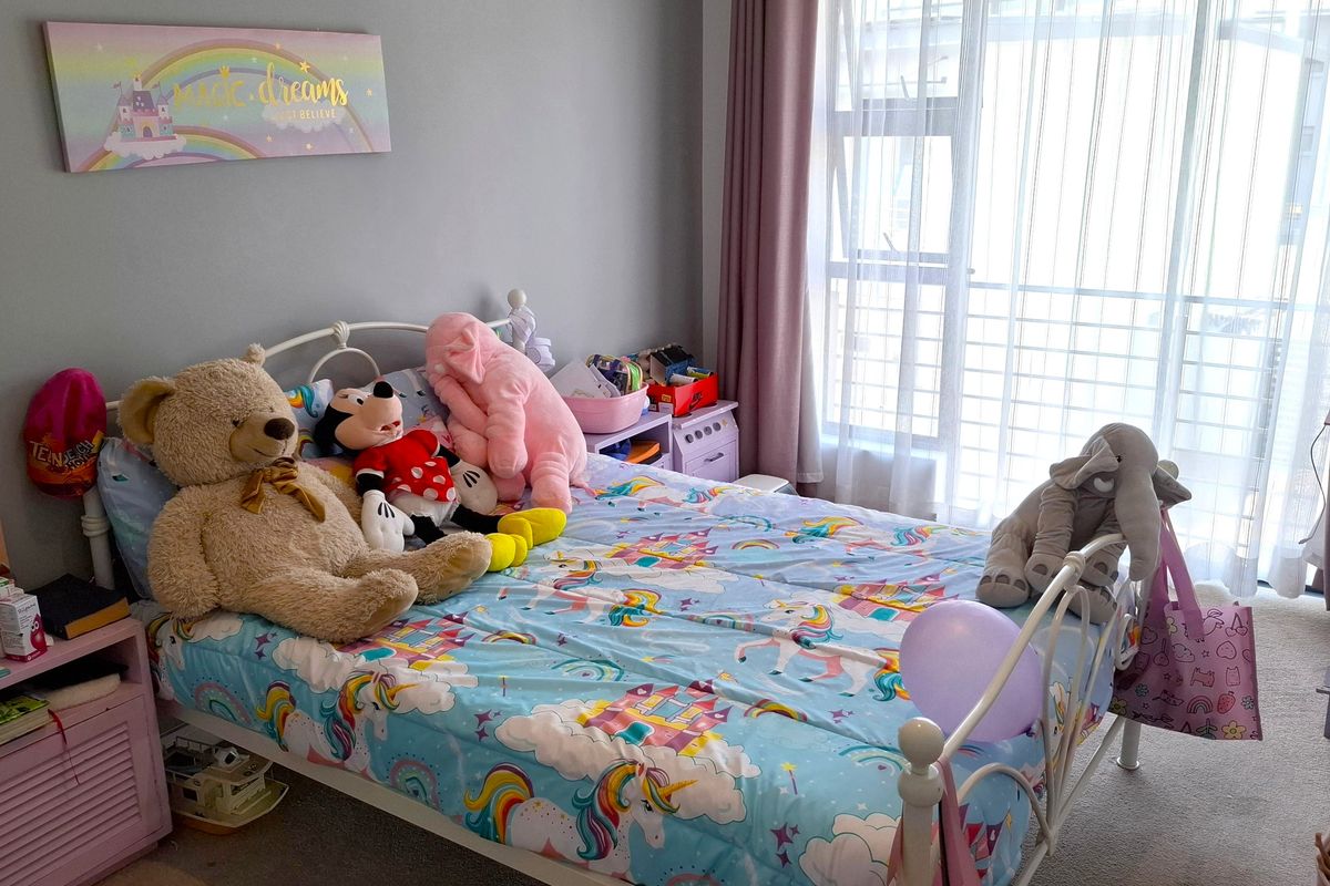 A bedroom featuring a sliding glass door with curtains, providing natural light and access to an outdoor area.