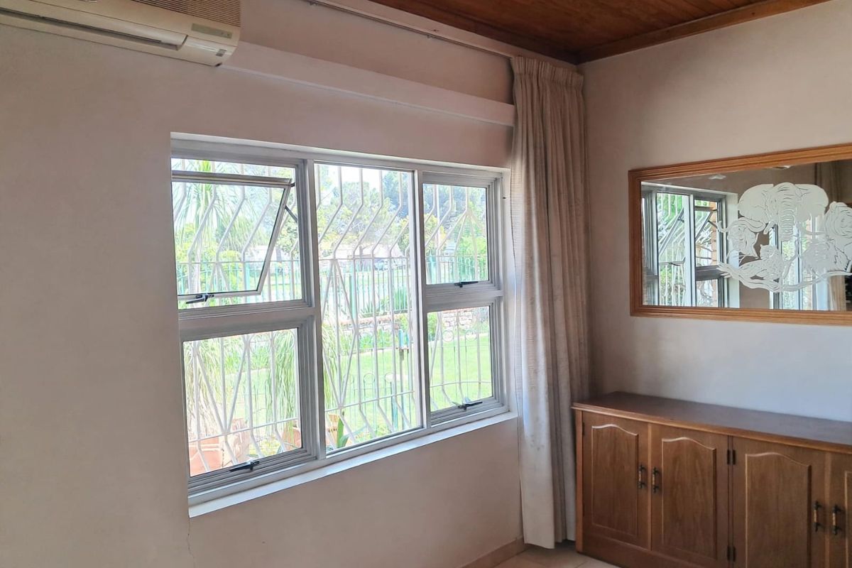 Bedroom featuring a timber ceiling, tiled flooring, air conditioning unit, and aluminium windows with security bars.