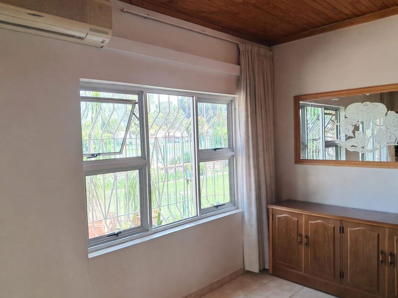 Bedroom featuring a timber ceiling, tiled flooring, air conditioning unit, and aluminium windows with security bars.