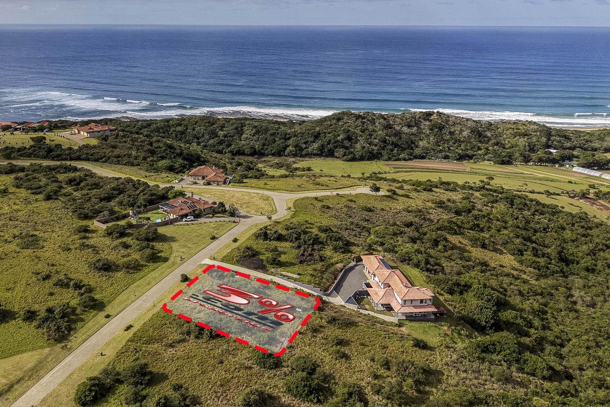 Aerial view of a vacant residential plot situated in a coastal estate, featuring proximity to the ocean and established access roads.