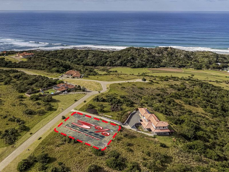 Aerial view of a vacant residential plot situated in a coastal estate, featuring proximity to the ocean and established access roads.