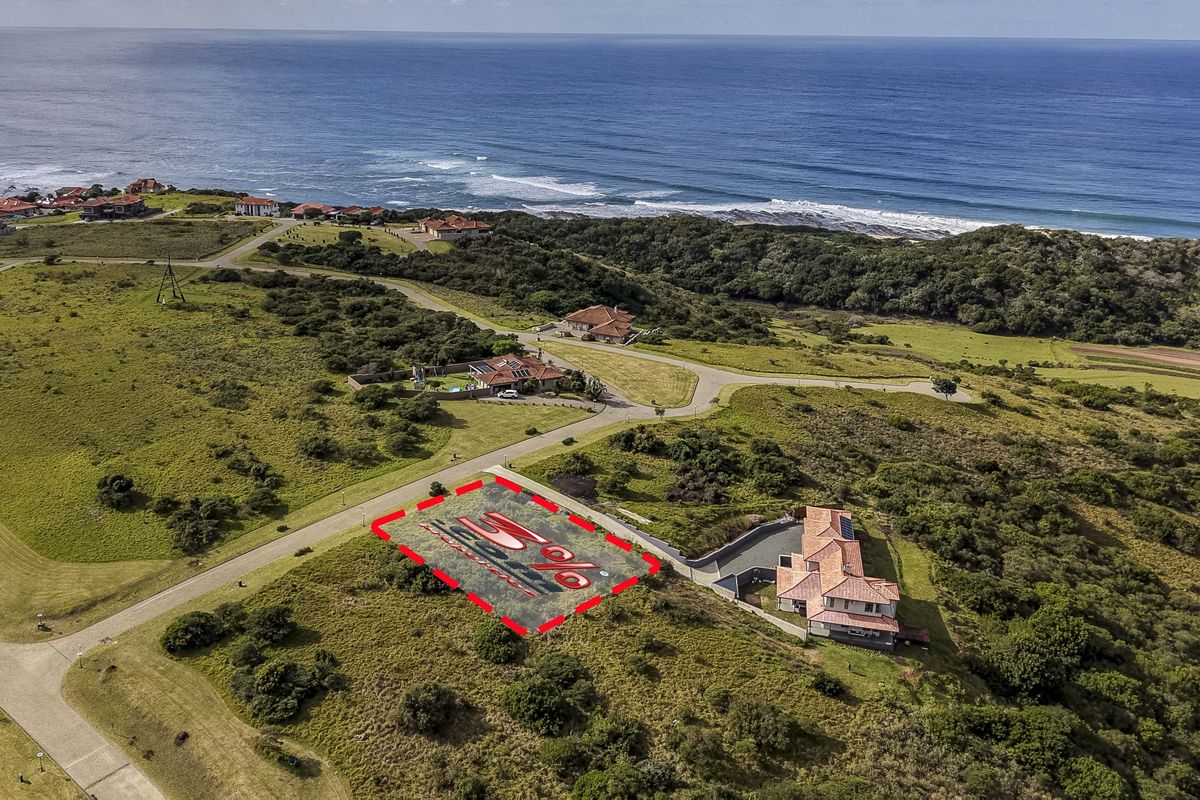 Aerial view of a vacant residential plot situated in a coastal estate, featuring proximity to the ocean and established road infrastructure.