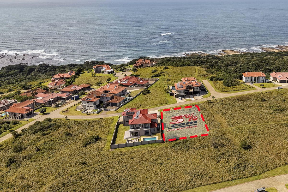 Aerial view of a vacant residential plot situated within a coastal estate, offering proximity to the ocean and established neighborhood infrastructure.