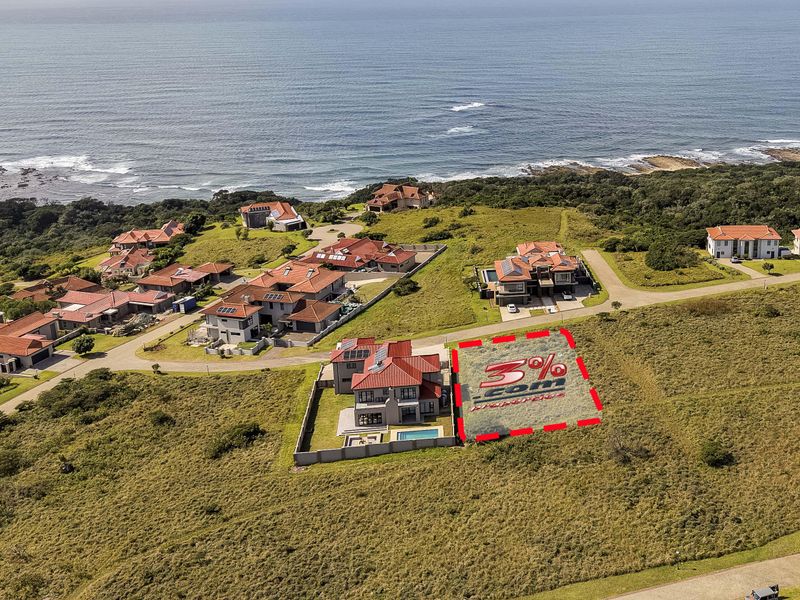 Aerial view of a vacant residential plot situated within a coastal estate, offering proximity to the ocean and established neighborhood infrastructure.