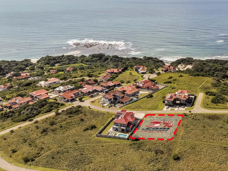 Aerial view of a vacant residential plot within a coastal estate, showcasing the surrounding neighborhood and proximity to the ocean.