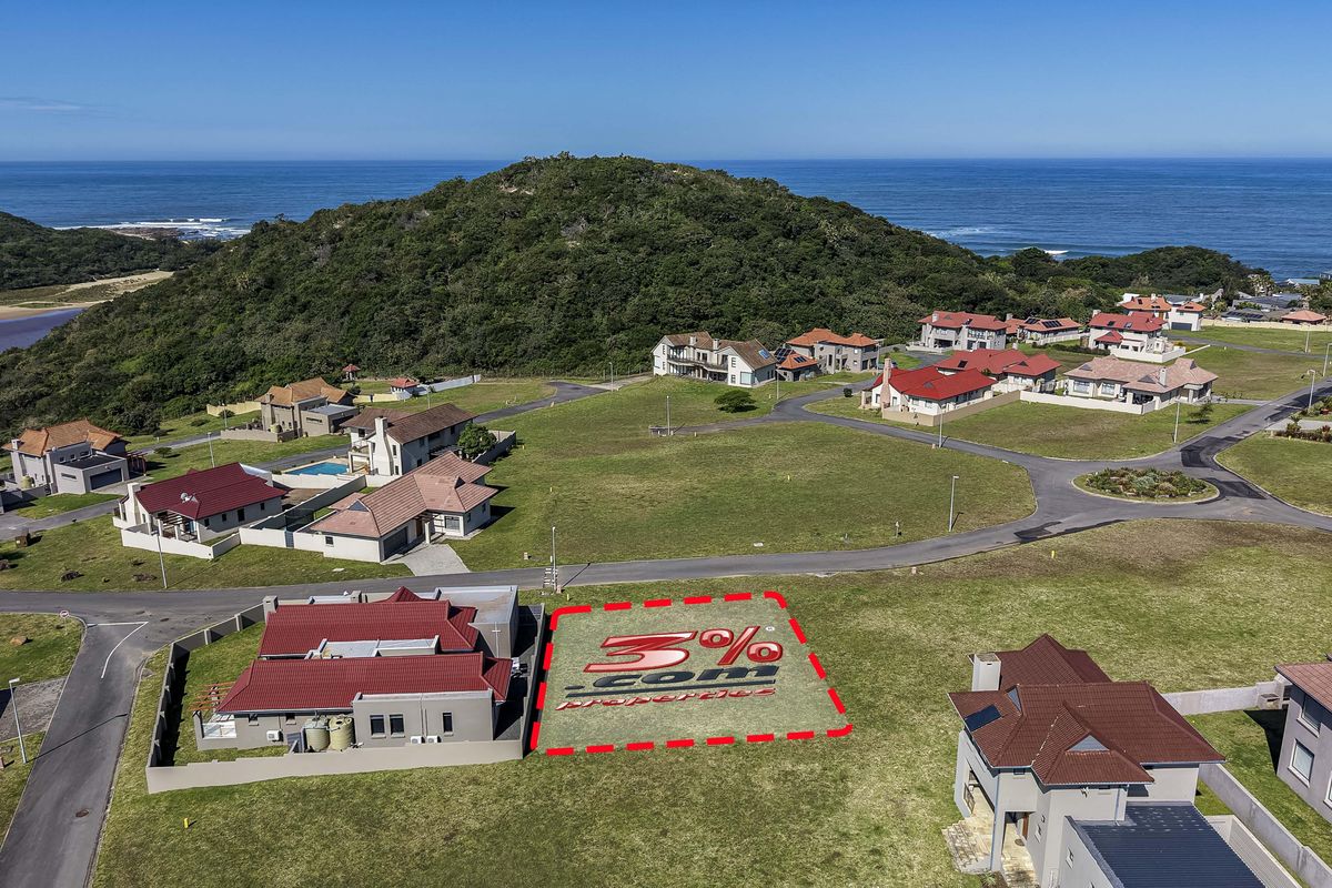 Aerial view of a vacant residential plot situated in a coastal estate, featuring road access and proximity to the ocean.