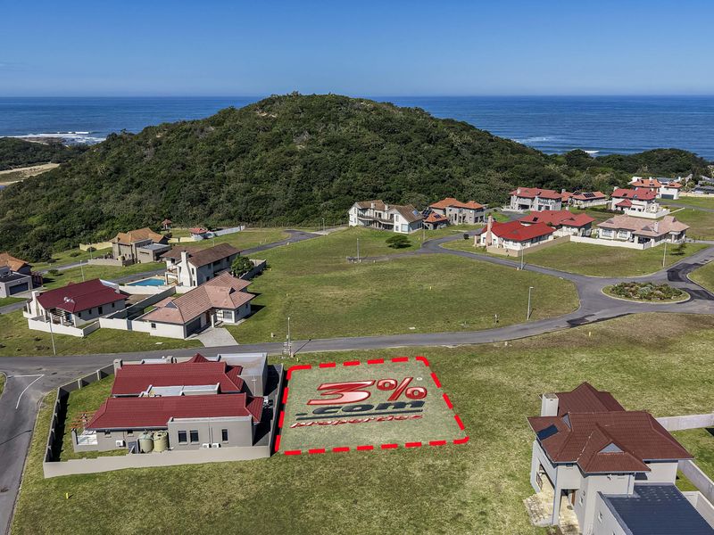 Aerial view of a vacant residential plot situated in a coastal estate, featuring road access and proximity to the ocean.