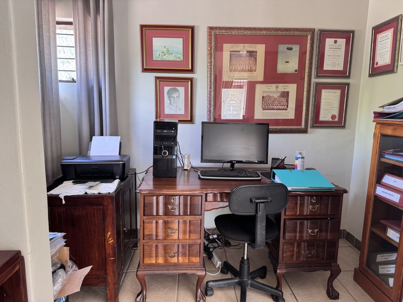 A functional home office space featuring tiled flooring and a window, providing a dedicated area for work or study.