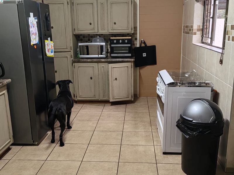 A functional kitchen featuring tiled walls and flooring, built-in cabinetry, and a gas stove, offering a practical layout for daily cooking.